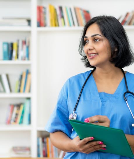 Nurse with clipboard in front of bookshelf