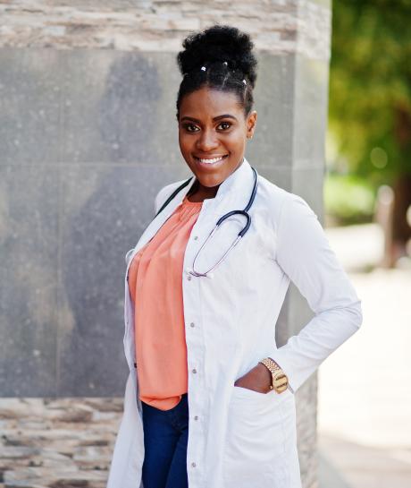 Nurse standing in labcoat outside