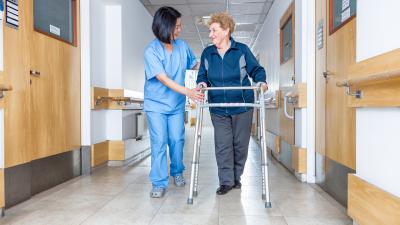 Nurse walking with patient in hallway